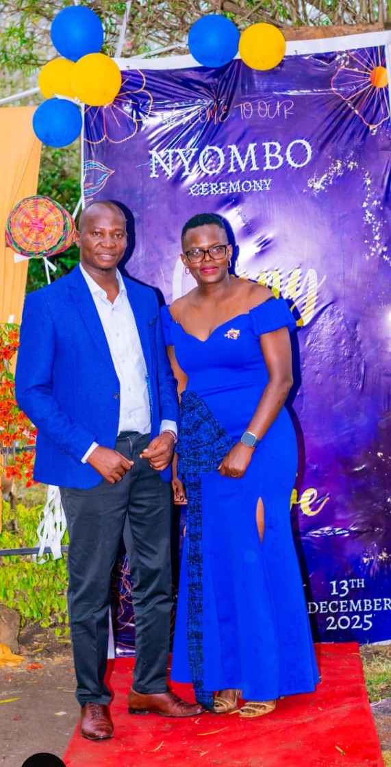 Couple posing at the Nyombo ceremony backdrop