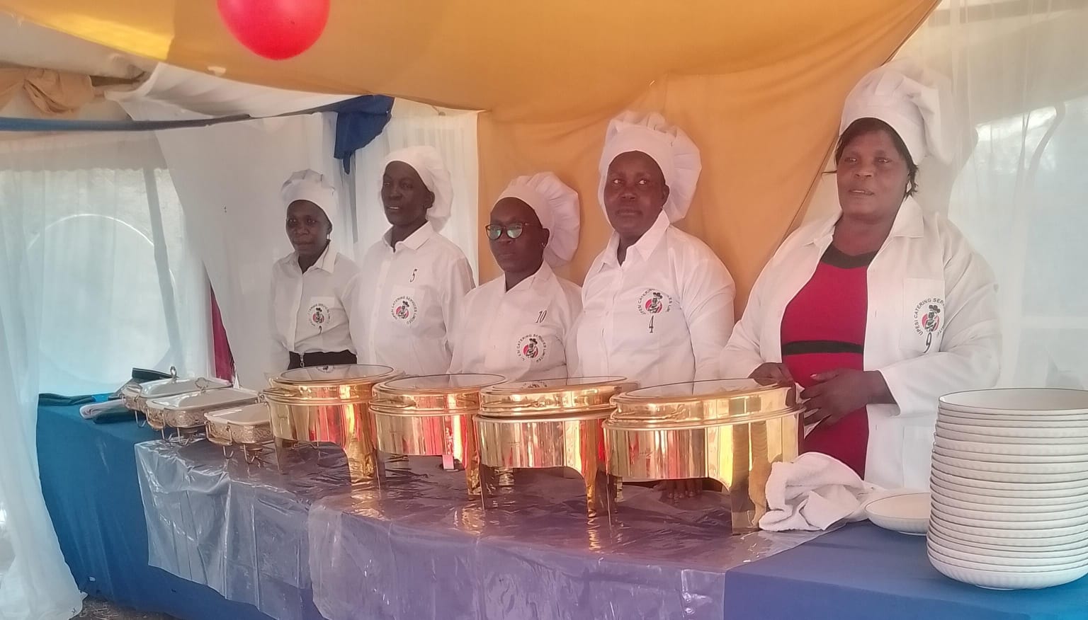 Uniformed catering team at the gold chafing buffet line